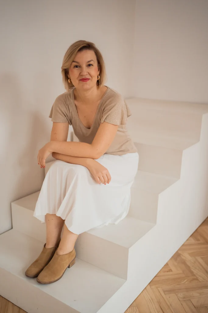 Agata Zielińska siedzi na schodach_ zdjęcie na stronę głowna Życie w zgodzie z własnym sercem